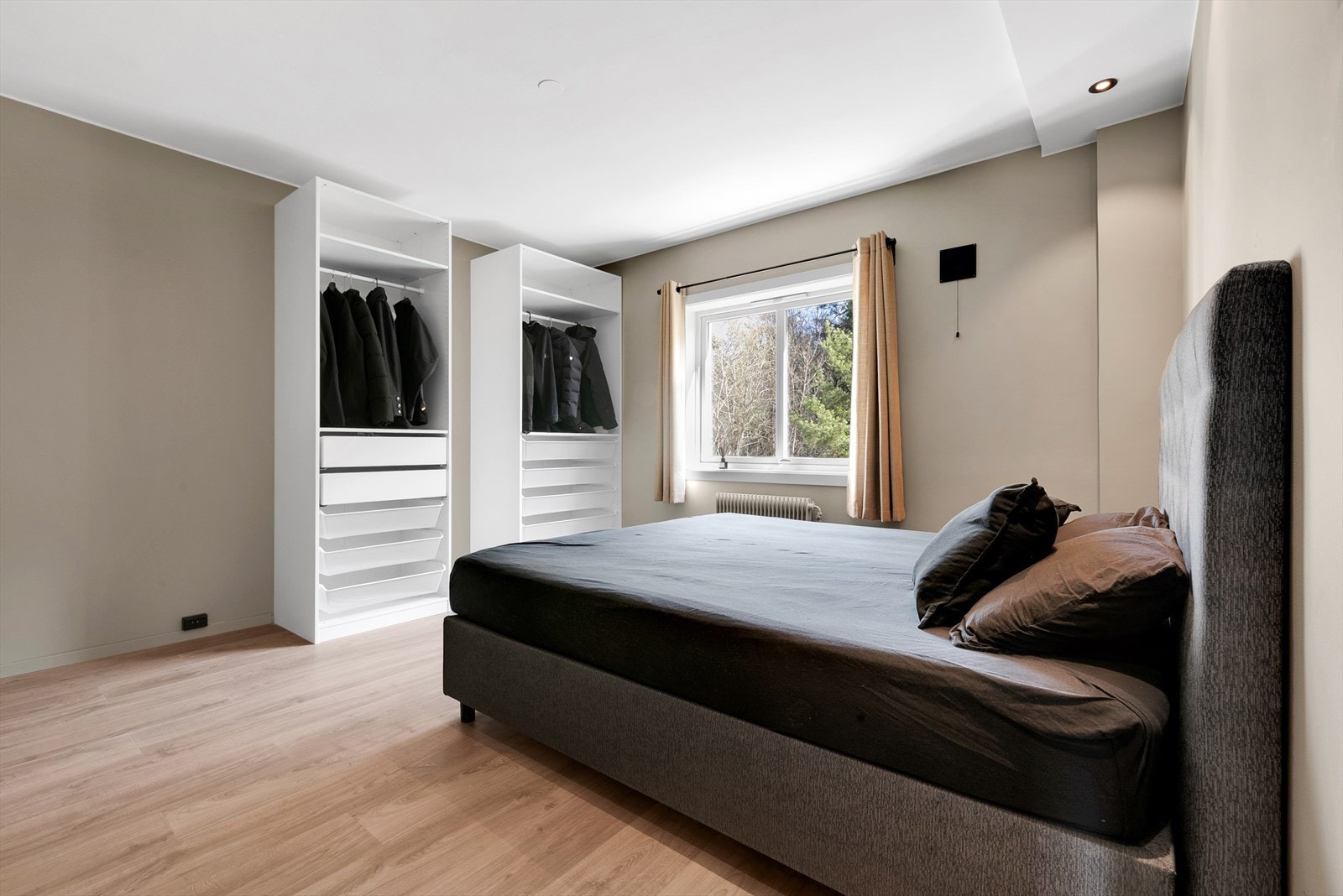 Soverom 1 med laminat på gulv, malte slette vegger og malt tak. Det er montert downlights og 2. stk åpne Ikea garderobeskap med oppheng, skuffer og kurver. Rommet har også inngang til en praktisk bod. Galleribilde