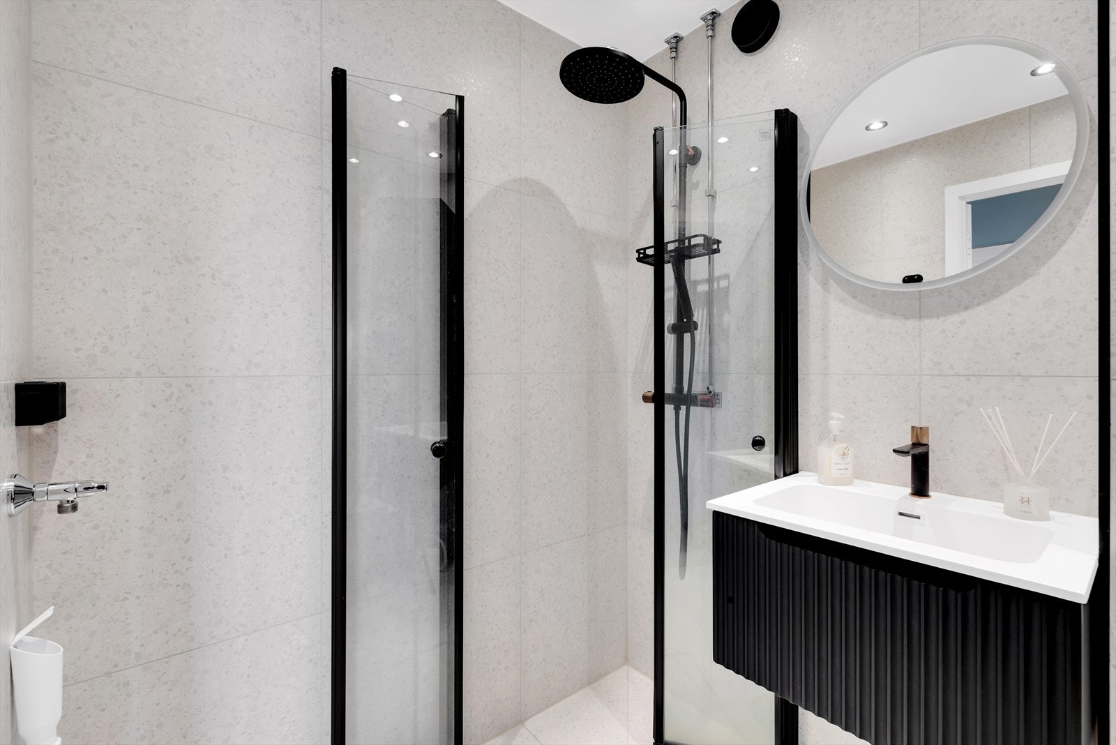 Innredningen består av hengslede dusjvegger, servant med underskuffer, speil med integrert lys, veggskap, vegghengt wc, opplegg for vaskemaskin og varmekabler i gulv. Galleribilde