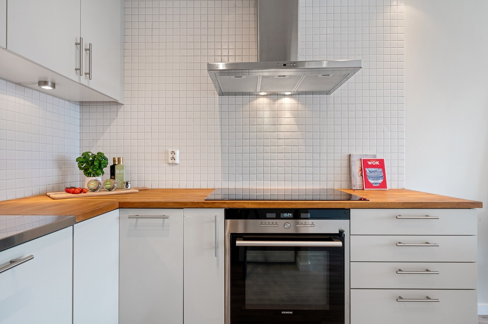 Integrerte hvitevarer som oppvaskmaskin, induksjonstopp og stekeovn. Galleribilde