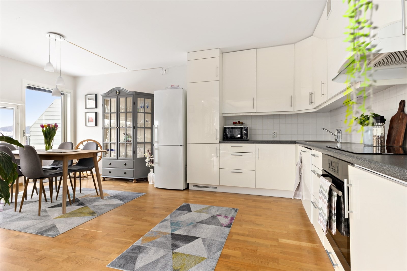 Belysning under overskap, og fliser mellom benkeplate og overskap. Kjøkkenet er utstyrt med integrerte hvitevarer som stekeovn, koketopp og oppvaskmaskin. Frittstående kjøleskap, som ikke medfølger i handelen. Galleribilde