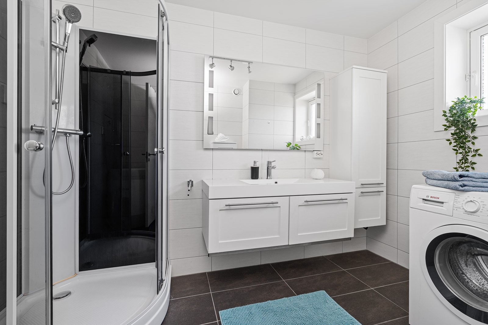 Badet er helfliset med tidsriktige fliser på gulv og vegger. Det er varmekabler i gulvet, samt plass og opplegg for vaskemaskin/tørketrommel. Nytt dusjkabinett ble satt inn av Tormod Bragdø AS i 2022. Galleribilde