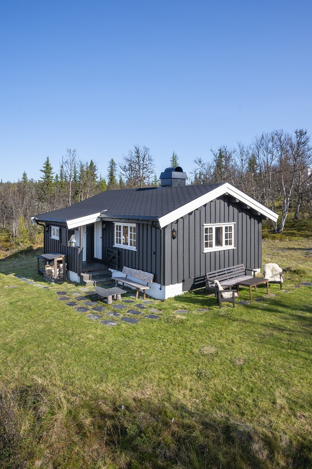 Eiet forholdsvis flat naturtomt med gressarealer, fjellbjørk og annen stedlig vegetasjon. Galleribilde