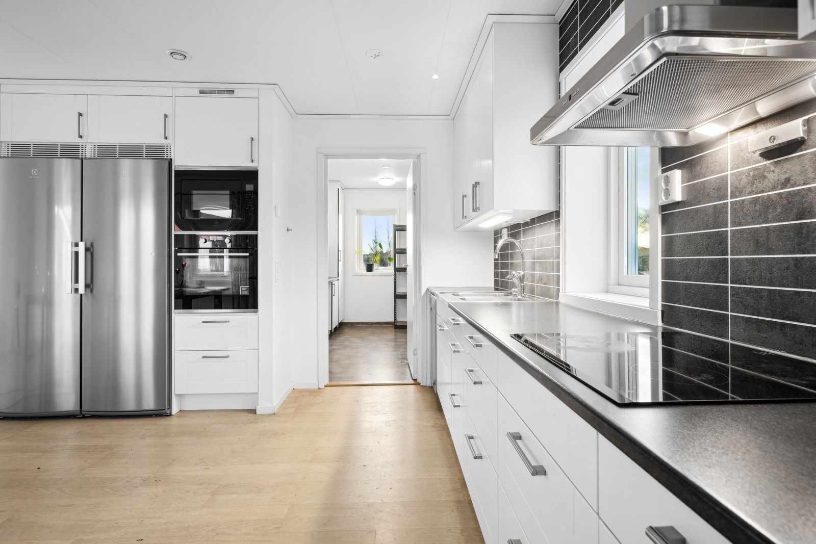 Kjøkkenet er utstyrt med komfyr og mikroovn i høyskap, oppvaskmaskin i benk og nedfelt platetopp. Galleribilde