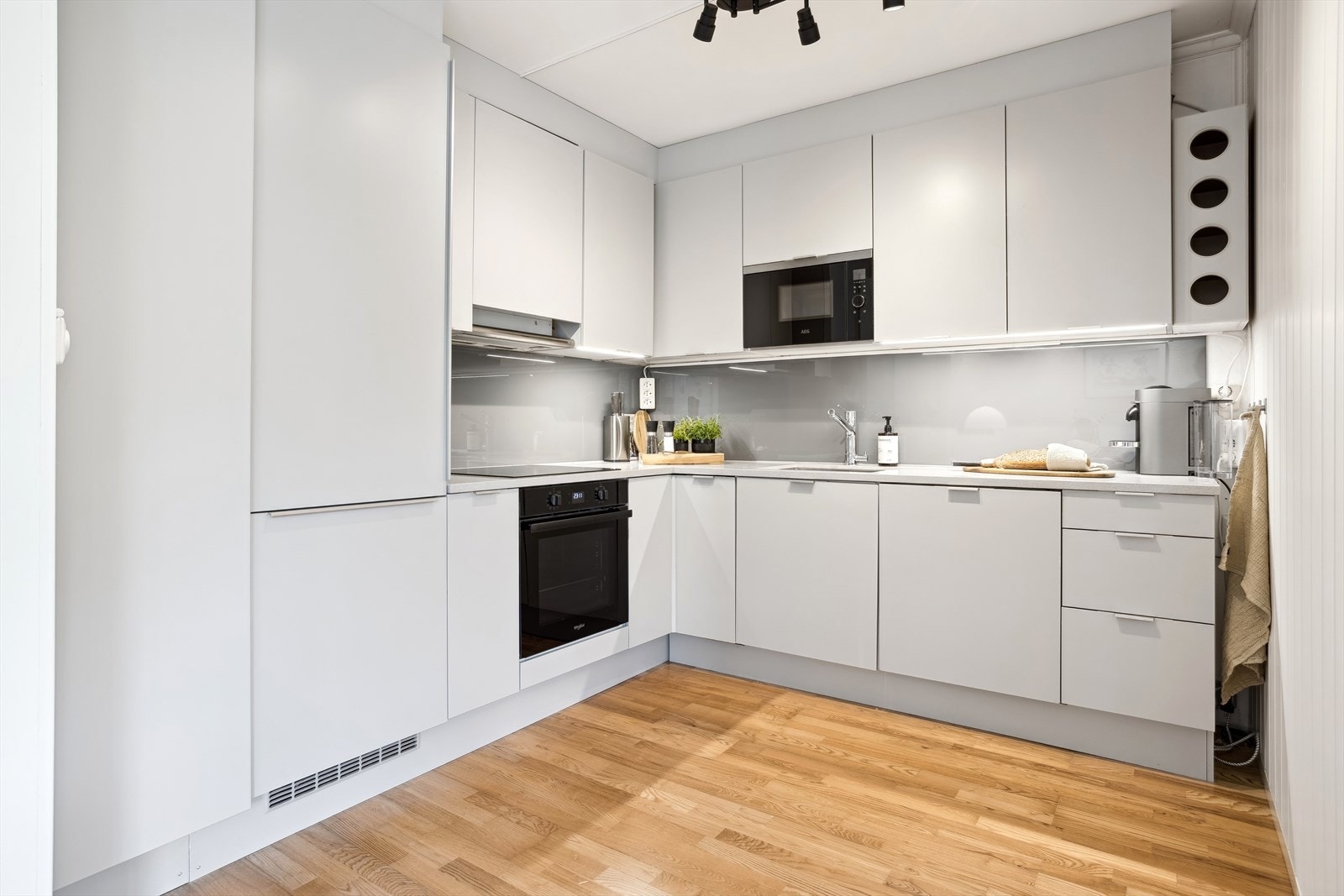 Kjøkket har glatte profilerte fronter og kompositt benkeplate Galleribilde