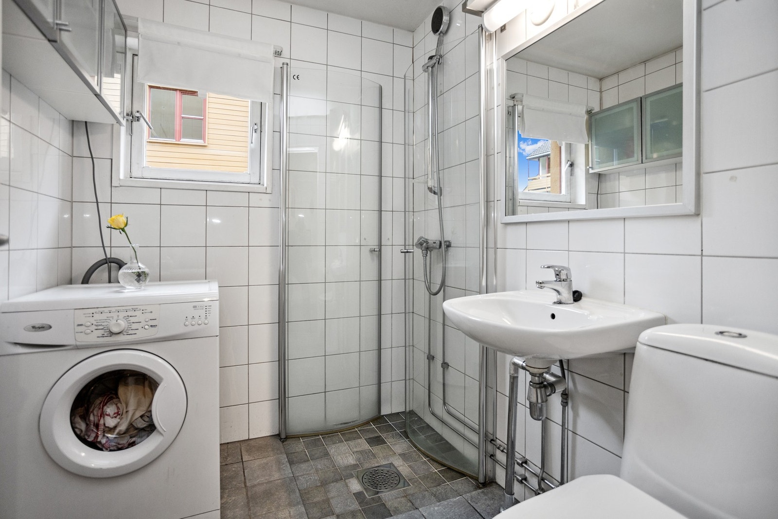 Flislagt bad med dushjørne og opplegg for vaskemaskin. Galleribilde