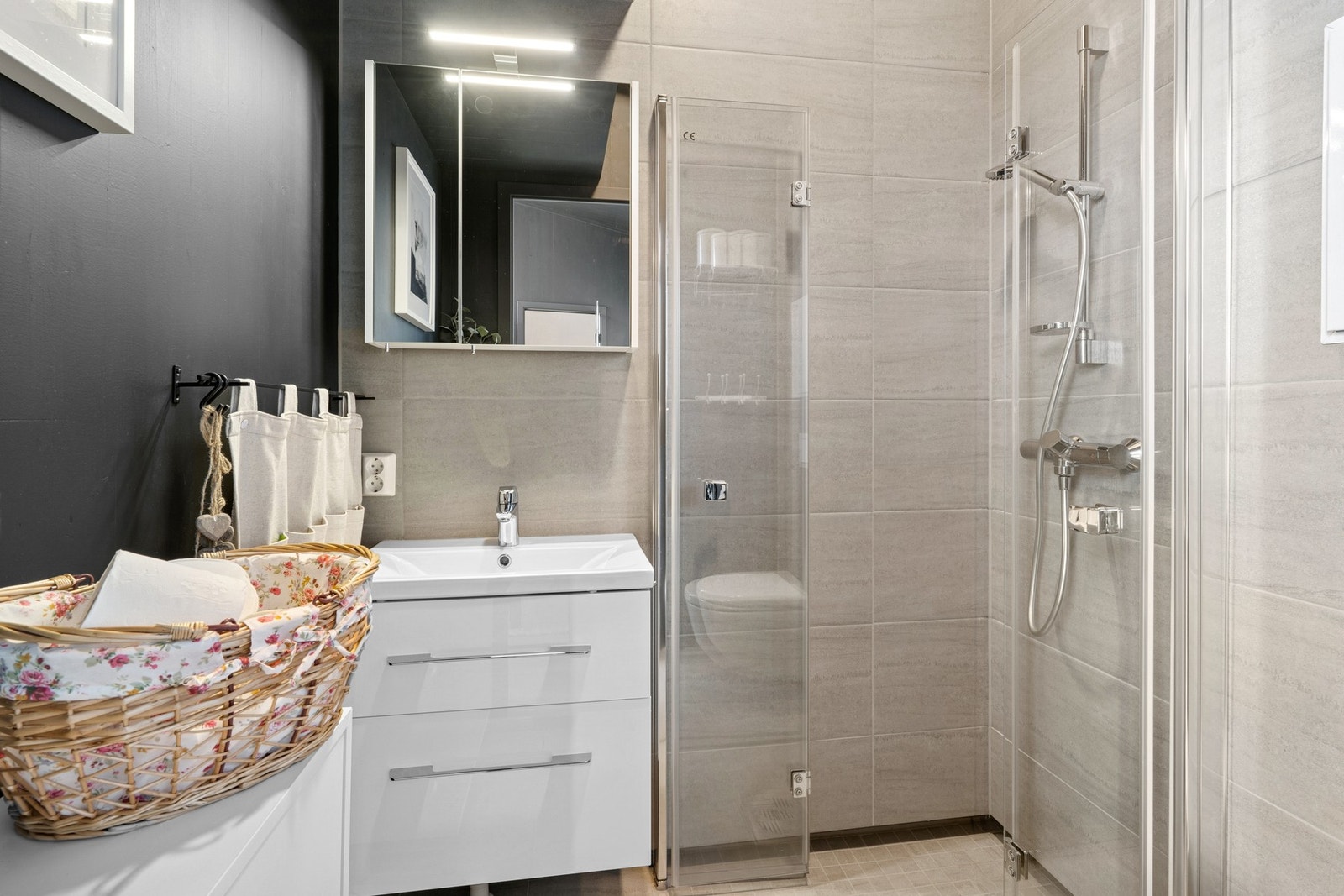 Flott flislagt bad med elektrisk gulvvarme. Badet har innfellbare glassdører og vegghengt speil med belysning. Galleribilde