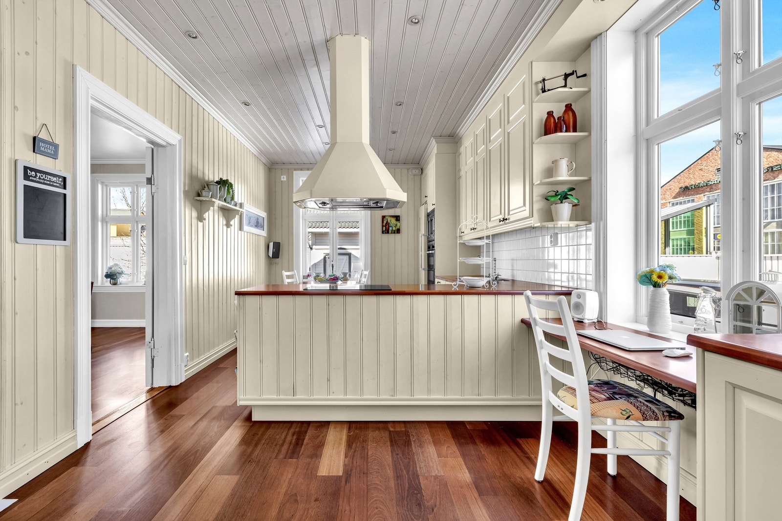 Den motsatte siden av kjøkkenøyen har en elegant løsning med lavere benkehøyde - et allsidig område som egner seg ypperlig til både hjemmekontor og barneaktiviteter. Galleribilde
