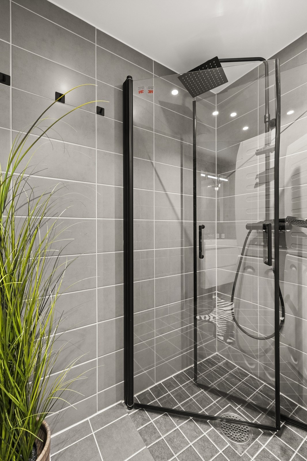 Badet har varme i gulv, innfellbare dusjdører, opplegg for vaskemaskin og tørketrommel, og servant med innredning Galleribilde