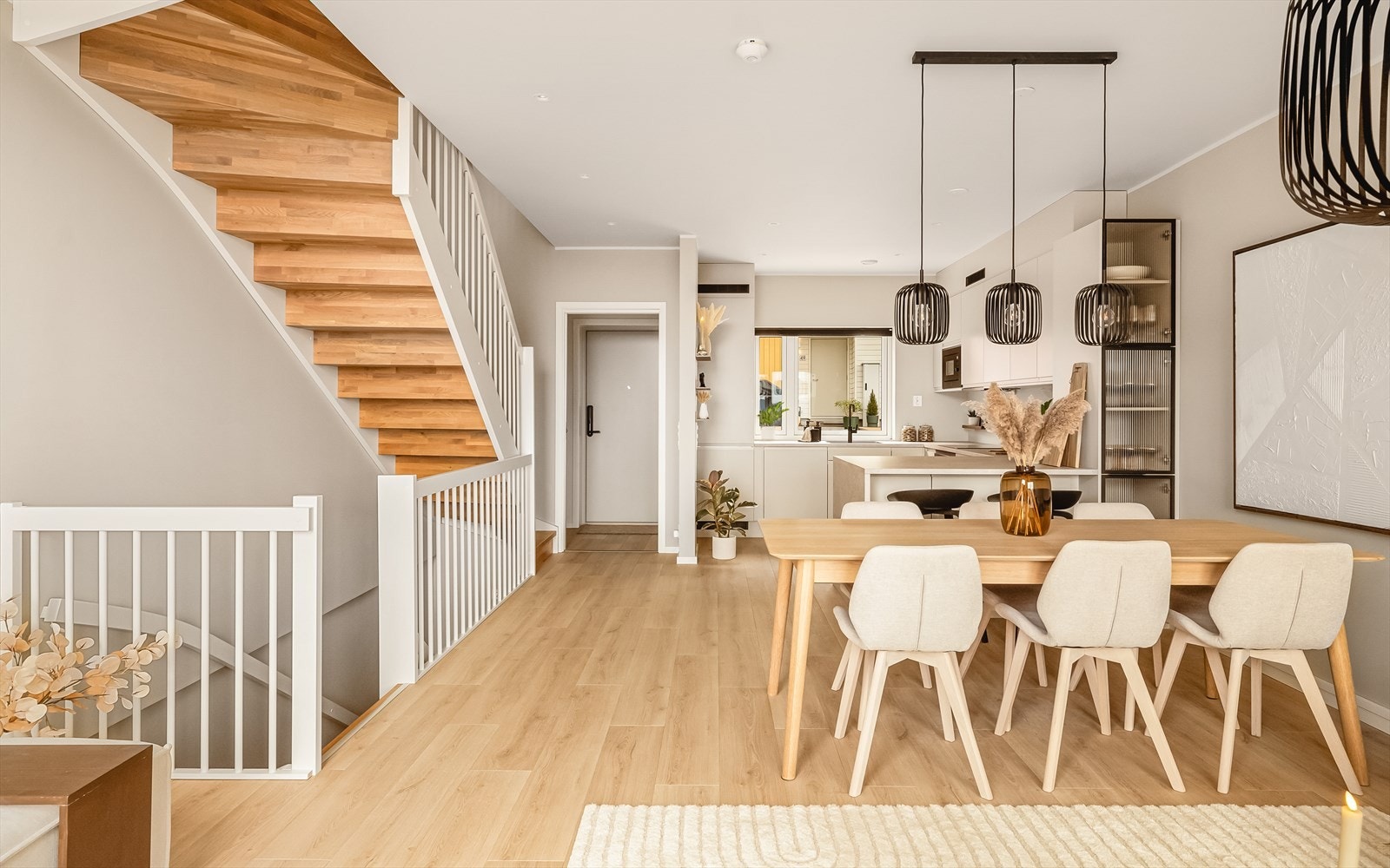 Fra entreen kommer du inn i boligens åpne stue-og kjøkkenløsning | Veggene er malt i den lekre fargen Blek Sand fra Jotun. Galleribilde