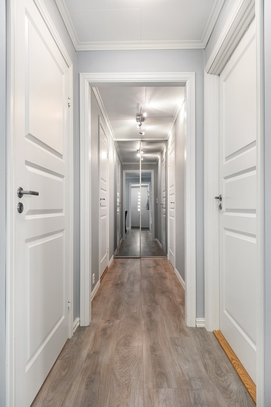 Gangarealet til bad, vaskerom og soverom. I enden er det garderobe med spegel i front. Galleribilde