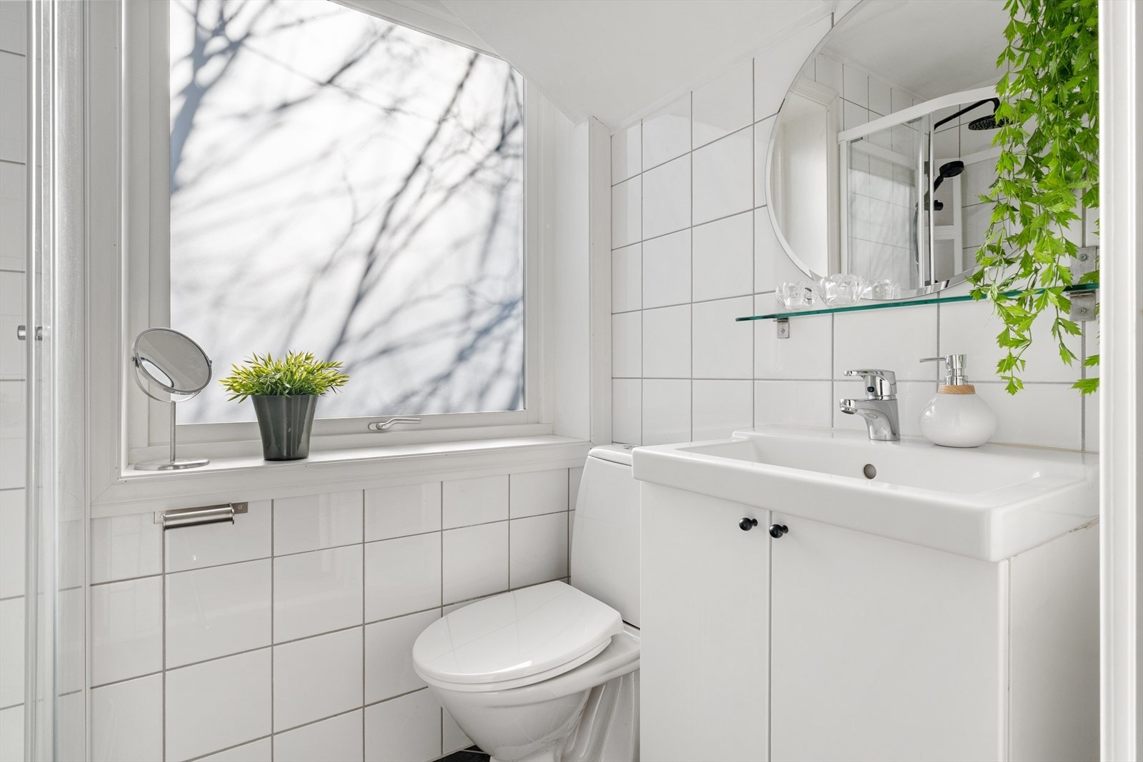 Badet har klassiske lyse fliser på vegger og mørke fliser på gulv. Galleribilde