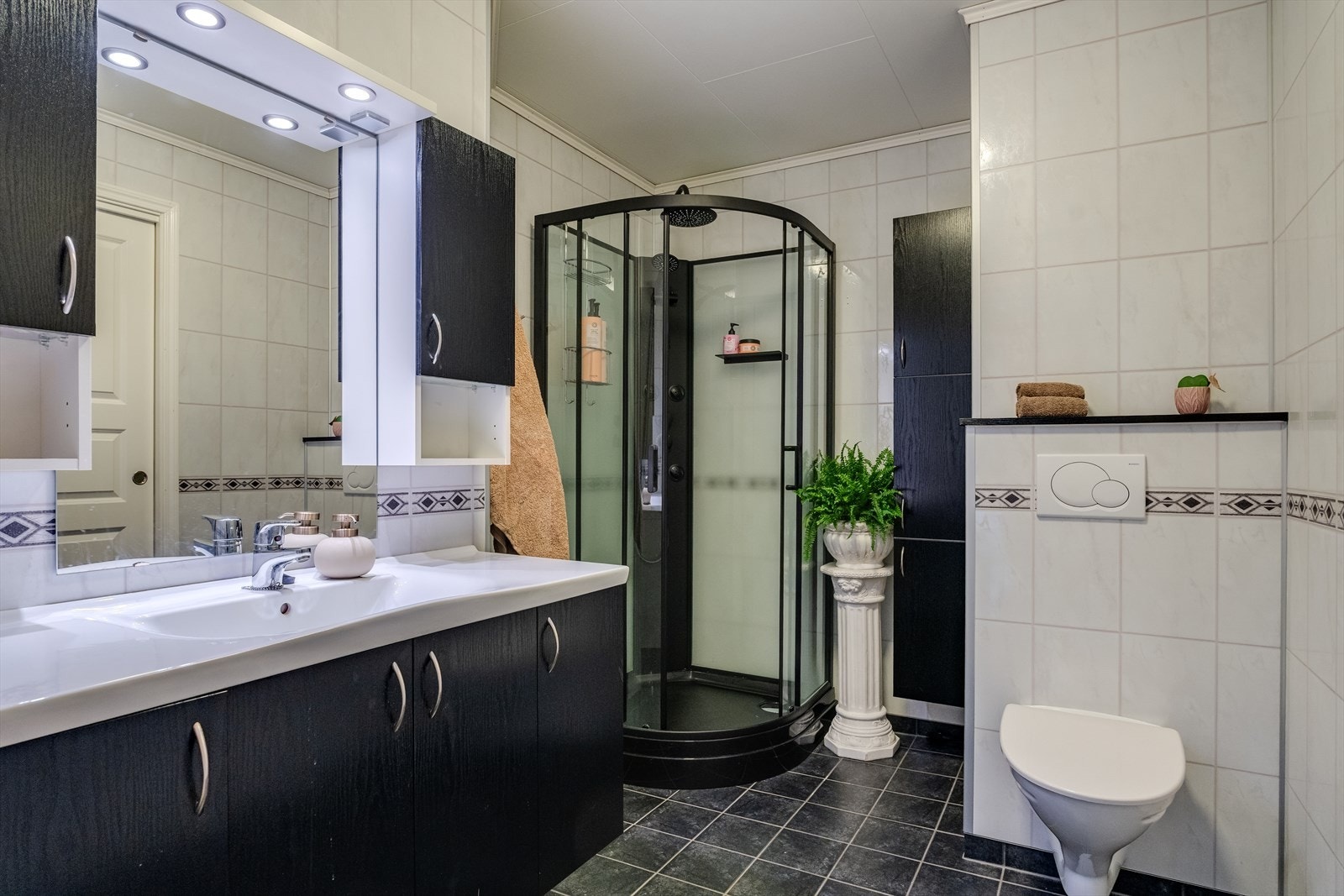 Pent bad med fliser på gulv og baderomsplater på vegger Galleribilde