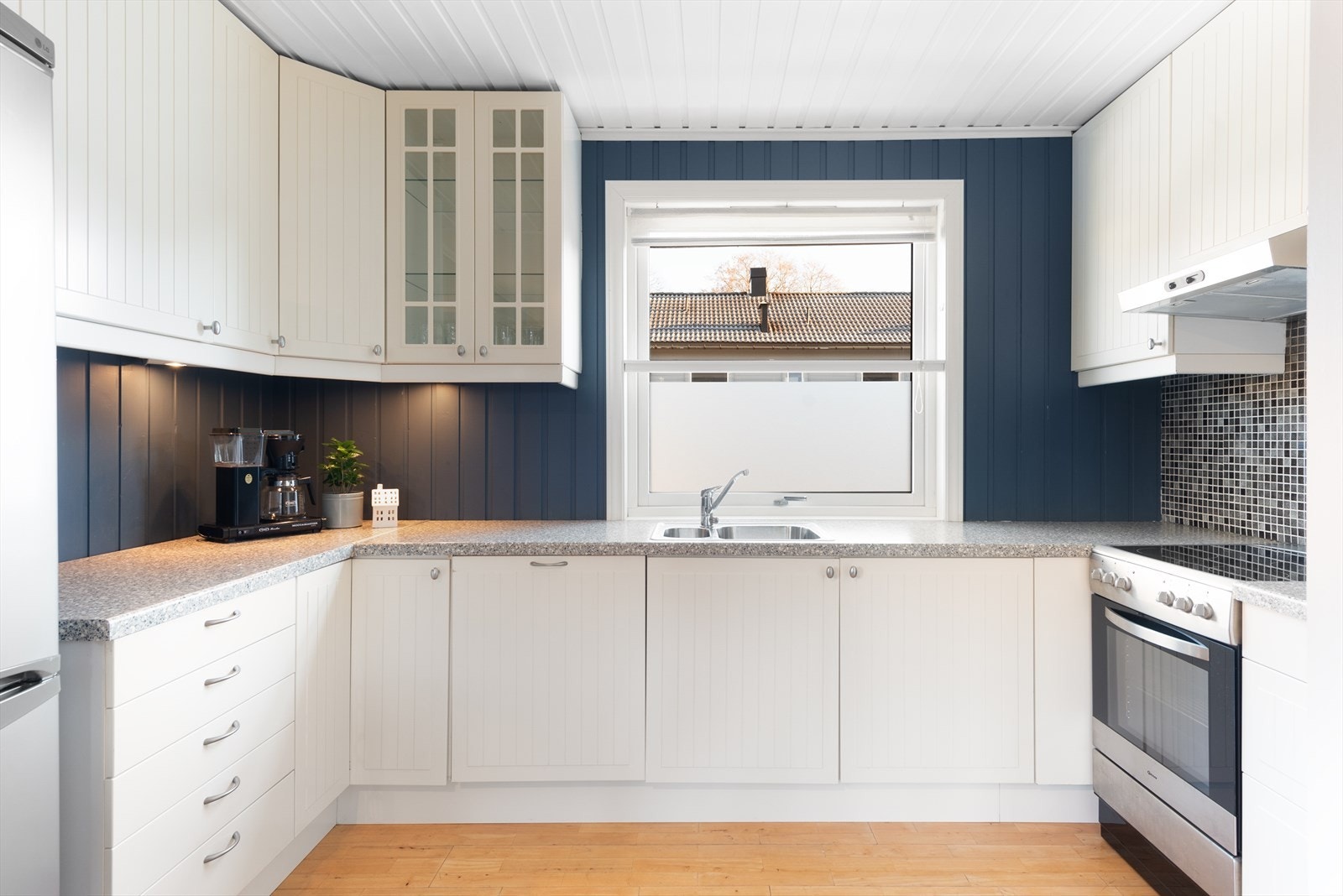 Kjøkkenet er utstyrt med malte fronter, laminerte benkeplater og praktisk kjøkkenventilator med avtrekk ut. Galleribilde