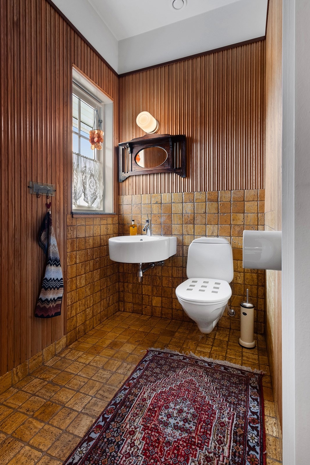 Toalettrommet i hovedetasjen har spilekledning på vegger og flislagt gulv. Galleribilde