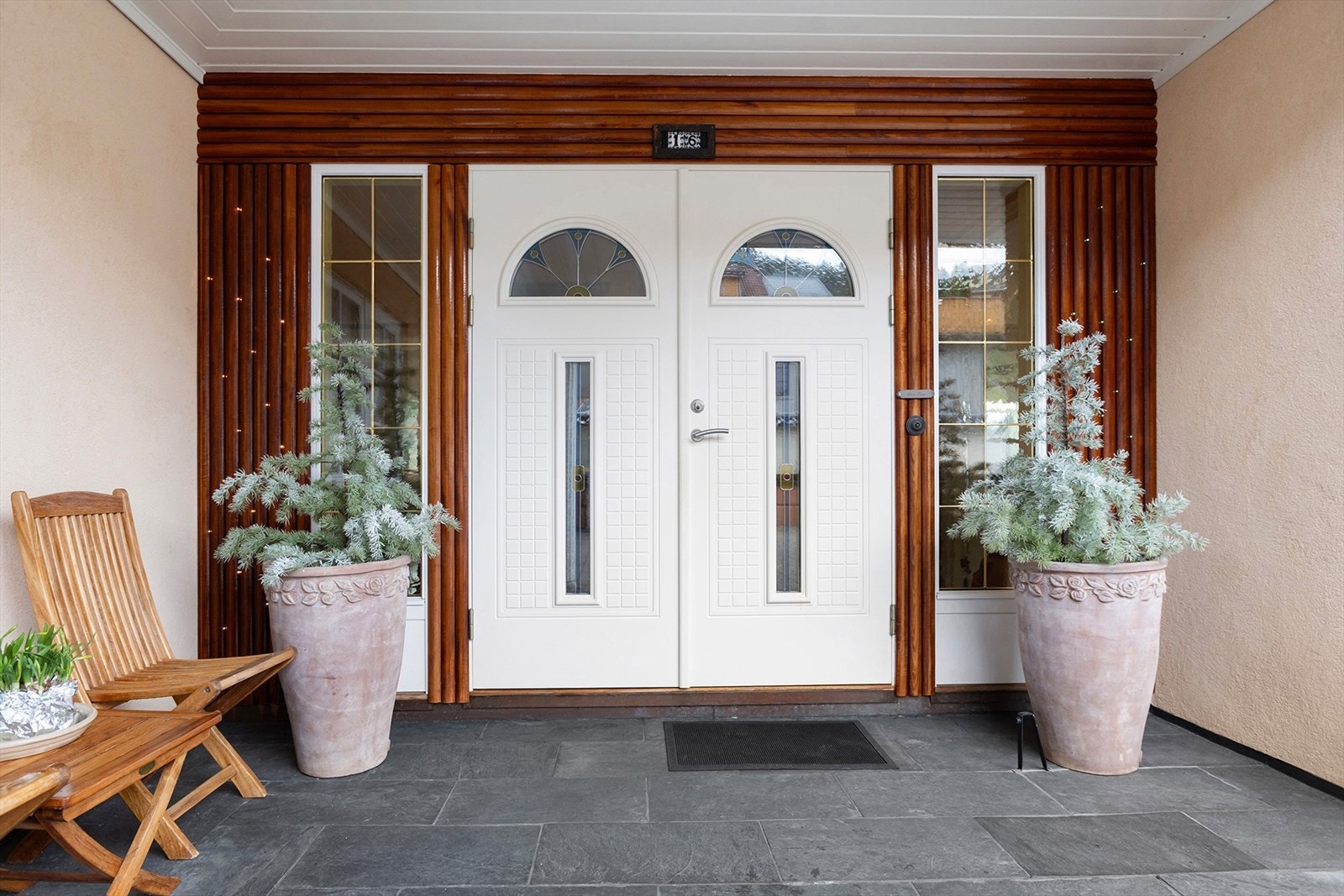 En tofløyet dør utvendig innrammet i solide teakspiler ønsker deg velkommen inn! Galleribilde