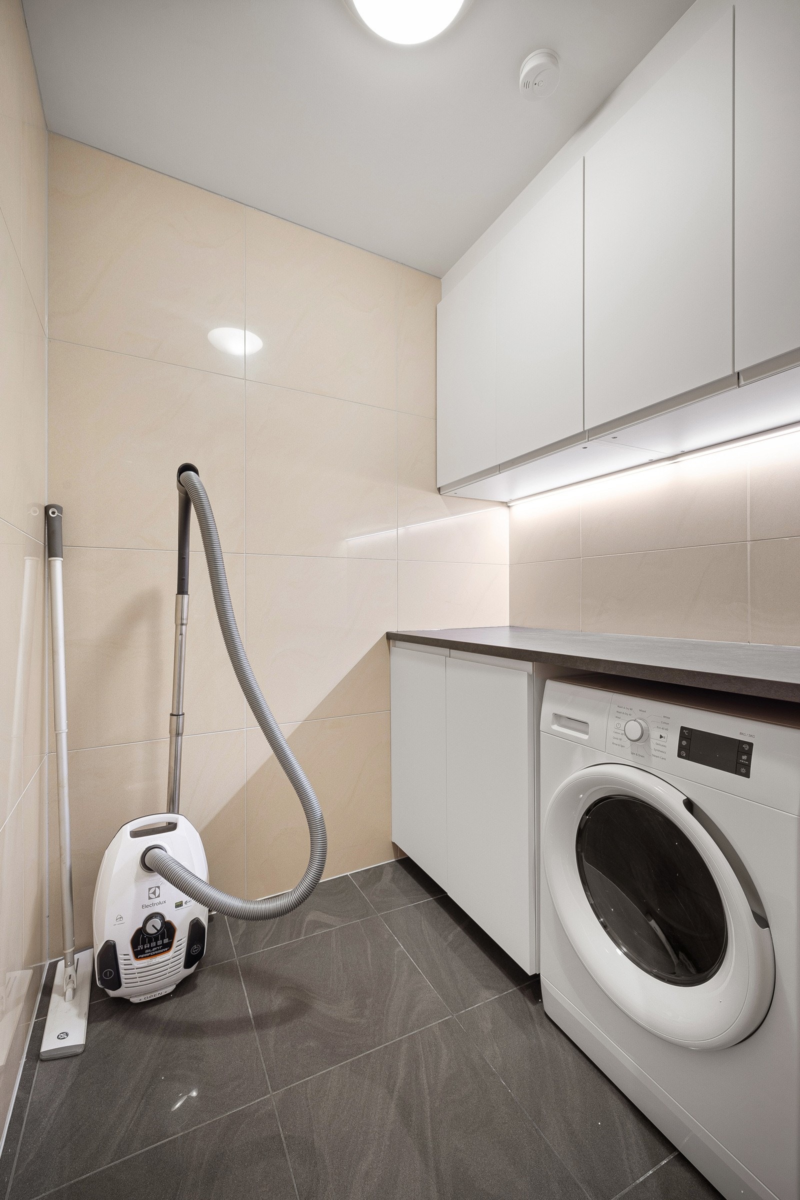 - Innenfor badet har du en helfliset bod/vaskerom med praktisk innredning og opplegg for vaskemaskin. God plass til ekstra oppbevaring - Galleribilde
