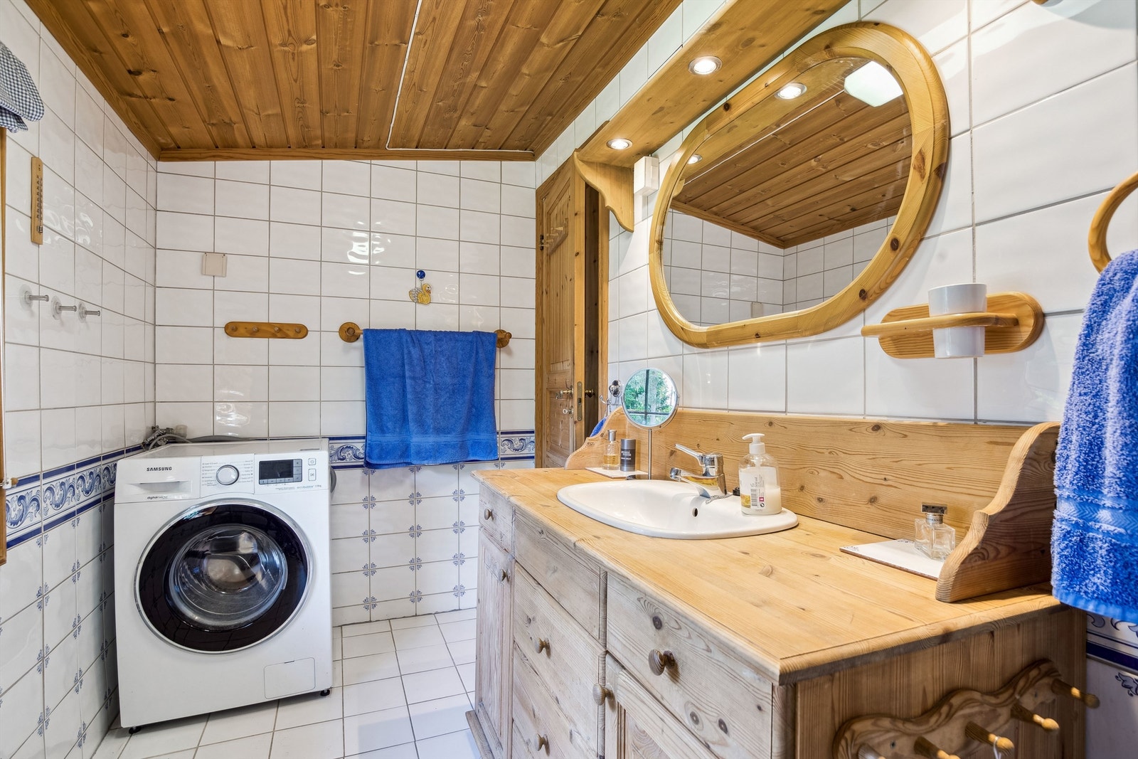 Badet er innredet med nedfelt servant, frittstående toalett og et dusjhjørne. Det er også opplegg for vaskemaskin. Galleribilde