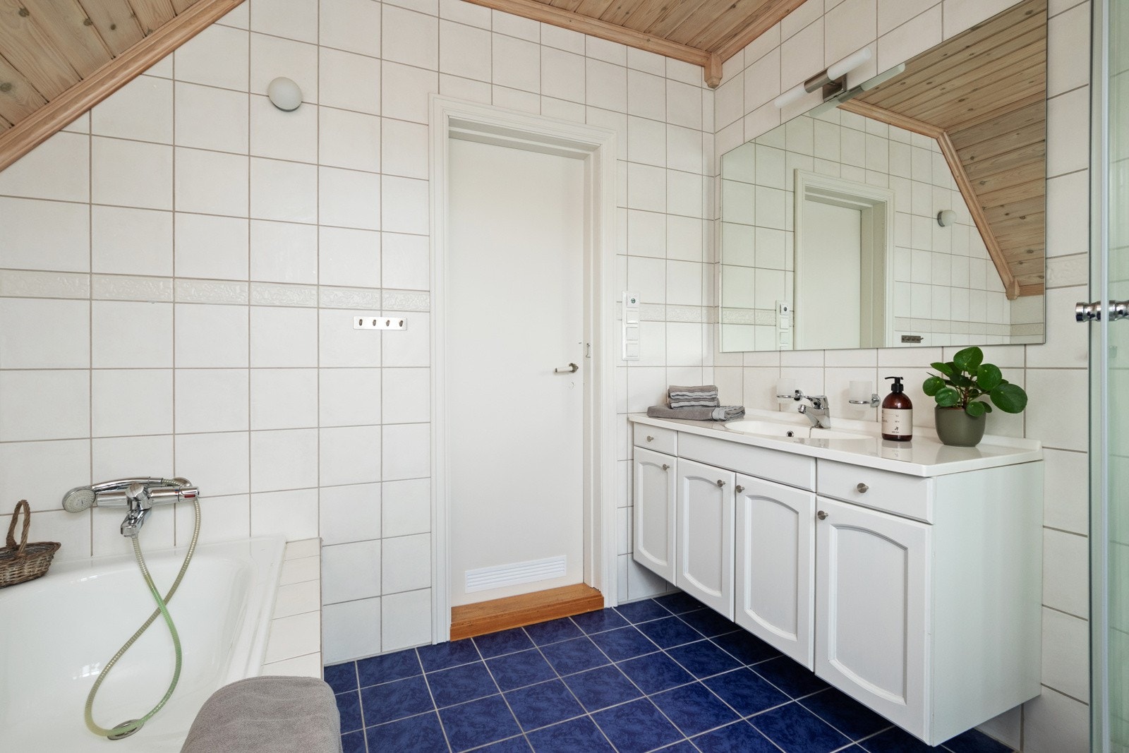 På badet er det både et dusjkabinett og et innfliset badekar med dusjløsning. Galleribilde