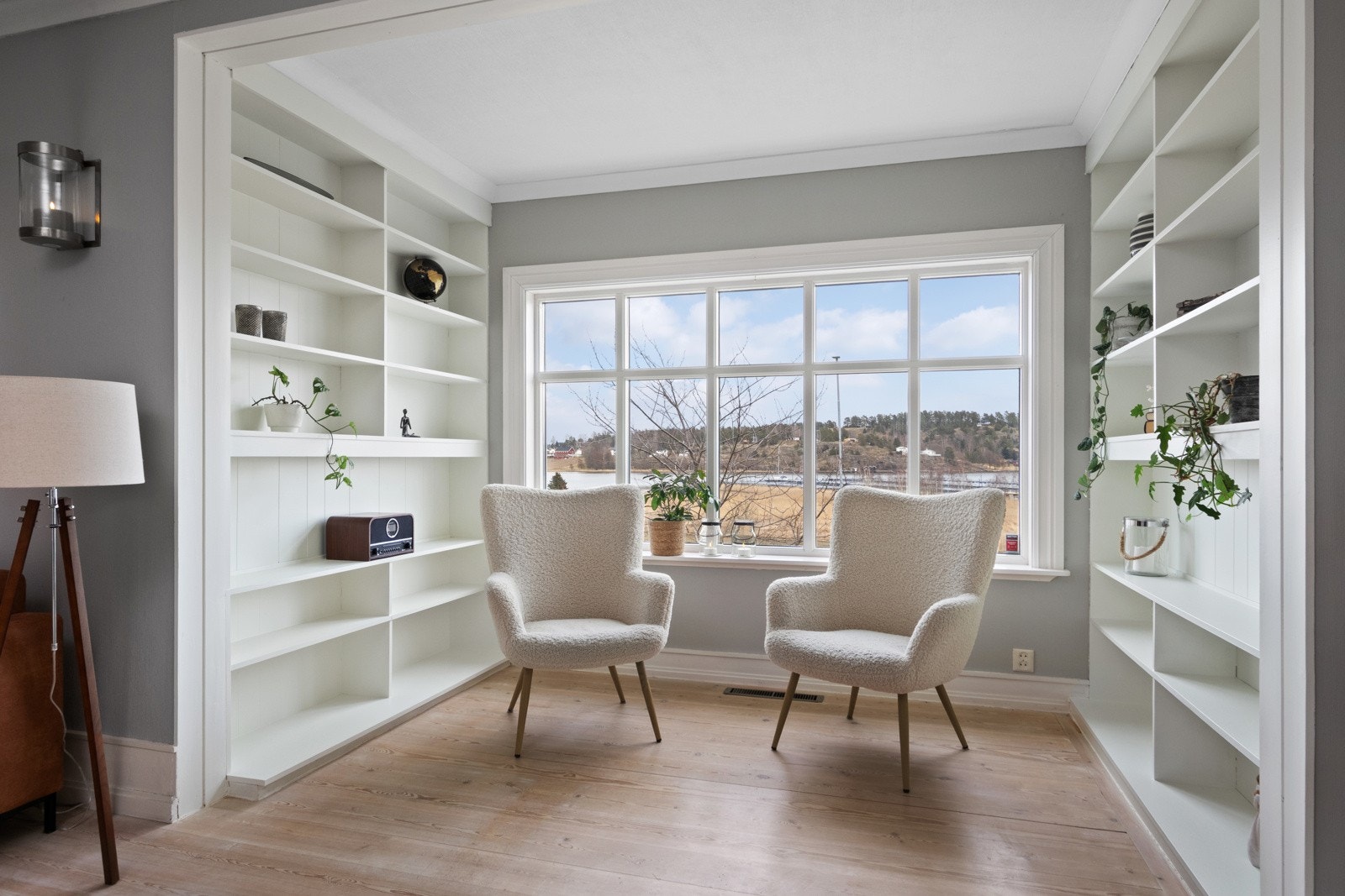 Et lite utstikk er innredet med to plassbygde hyller på hver sin side, perfekte for bøker, planter og annen dekor. Galleribilde