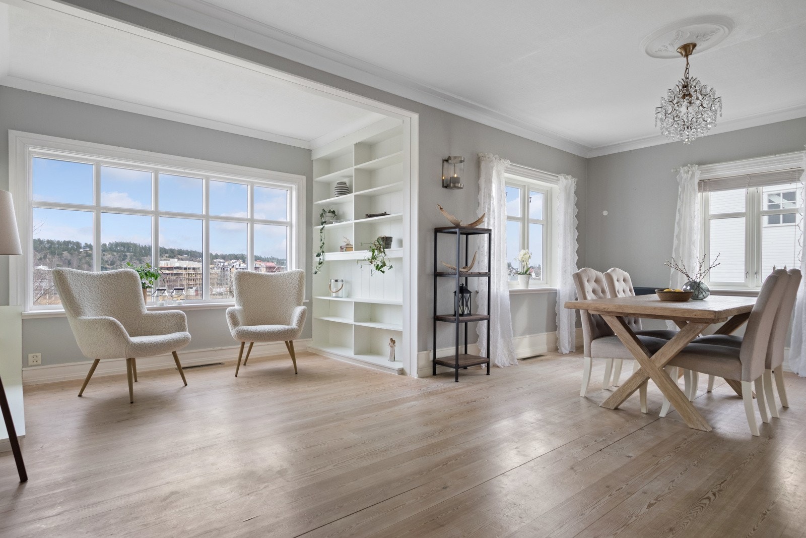 I taket har stuen to vakre rosetter, og et 1-stavs parkettgulv står godt til gråmalte vegger. Galleribilde