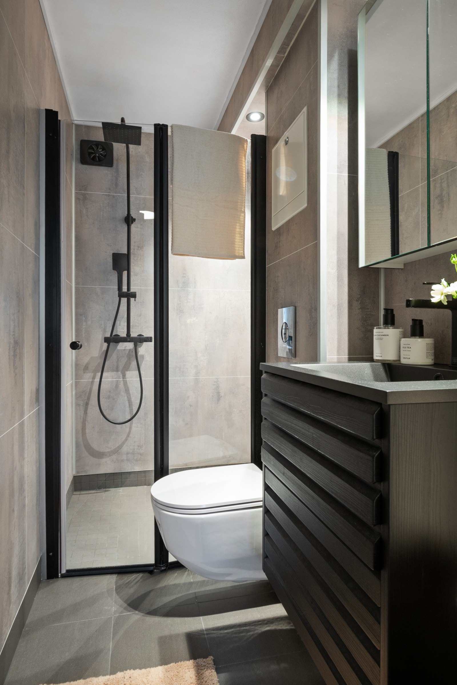 Dusjhjørnet er utstyrt med sort regnfallsdusj og en foldbar glassdør i sort innramming. Galleribilde