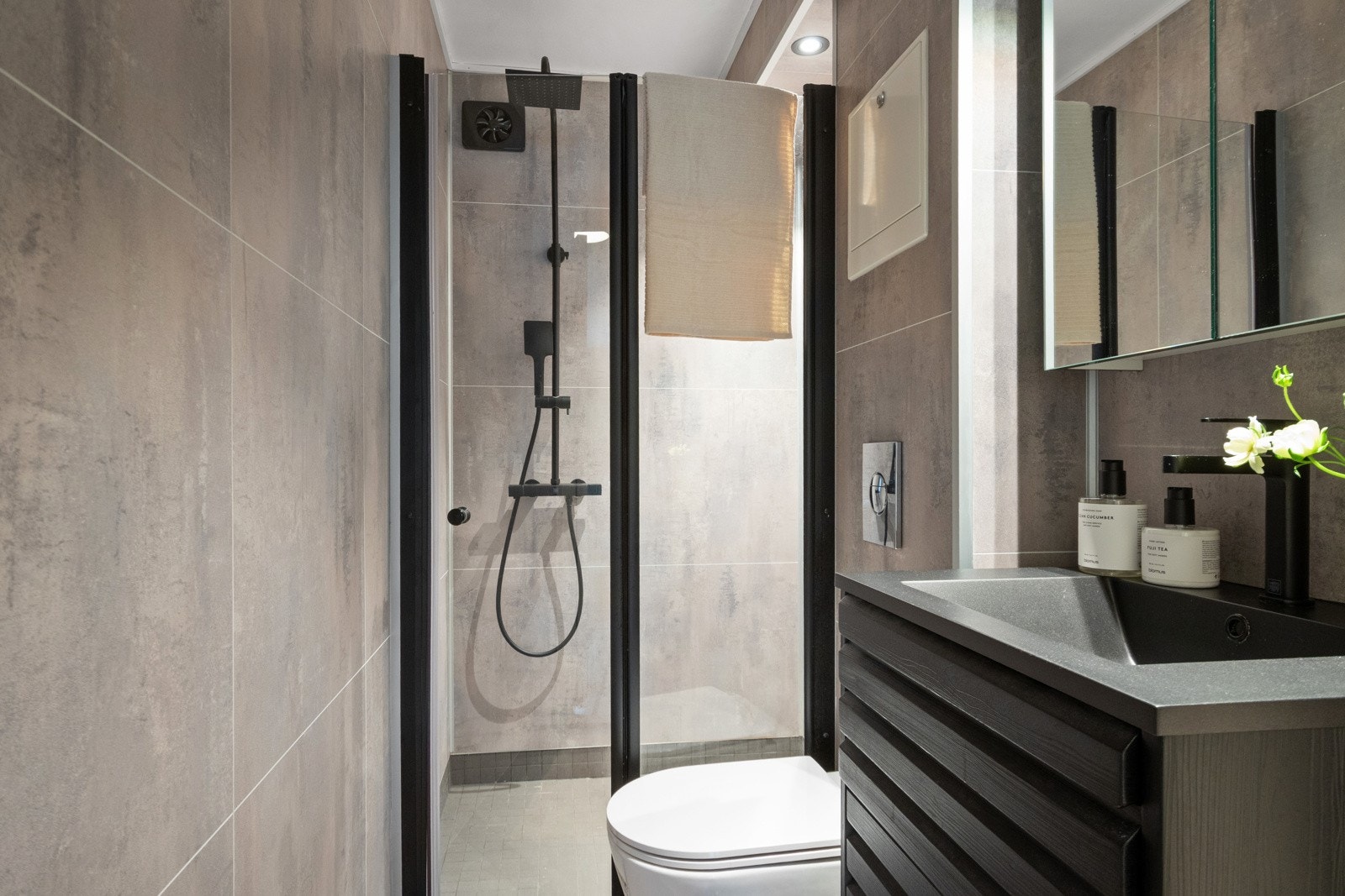 Badet ble pusset opp i 2023, innredet med store, grå gulvfliser og matchende våtromsplater på veggene. Galleribilde