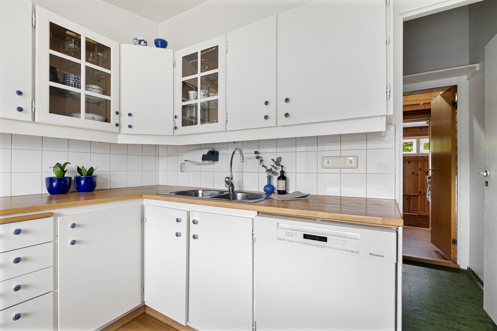 Kjøkkeninnredningen har klassiske, hvite fronter og en solid, oljet benkeplate med nedfelt kjøkkenvask. Galleribilde