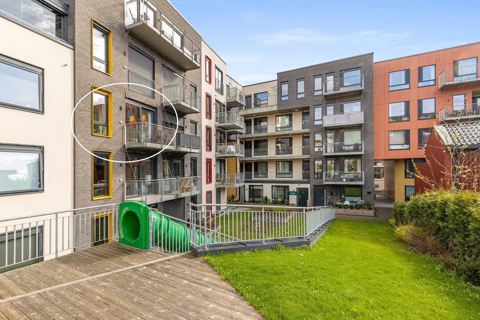 Tomten er pent opparbeidet med plen, lekeområde og diverse beplantninger Galleribilde