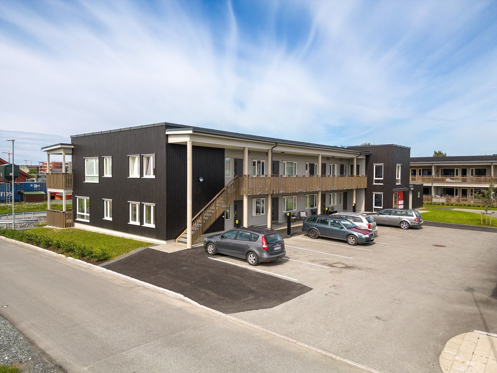 Inngangsparti med parkeringsplasser i front av boligen. Galleribilde