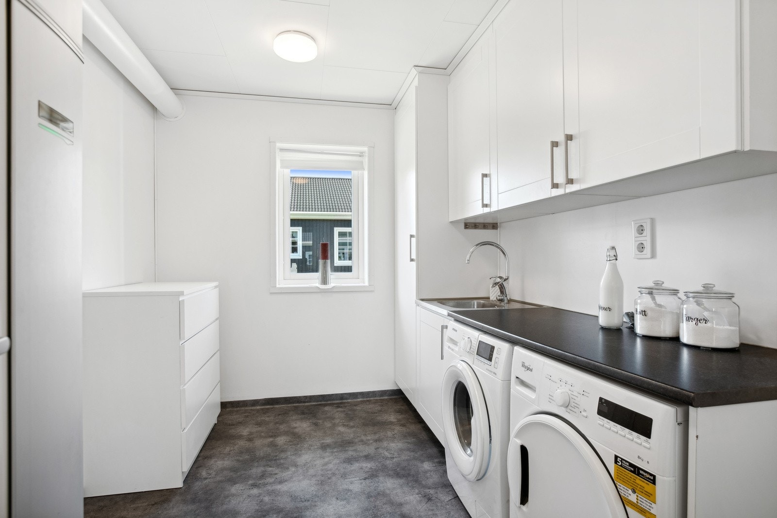 Boligen har eget vaskerom, med en praktisk løsnign for vaskemaskin og tørketrommel. Galleribilde