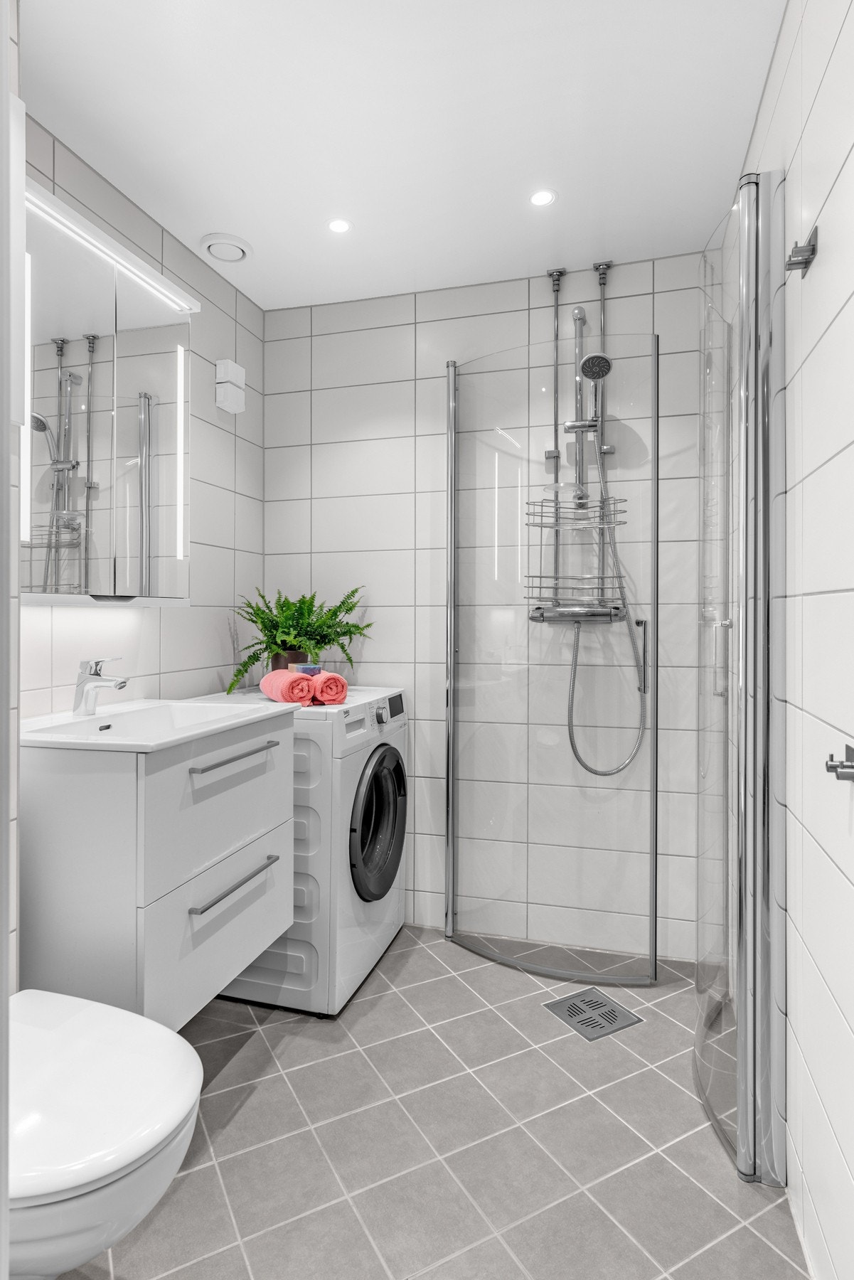 Moderne og pent flislagt baderom med varmekabler i gulv og downlights i tak, rehabilitert i 2020 i regi av borettslaget. Galleribilde