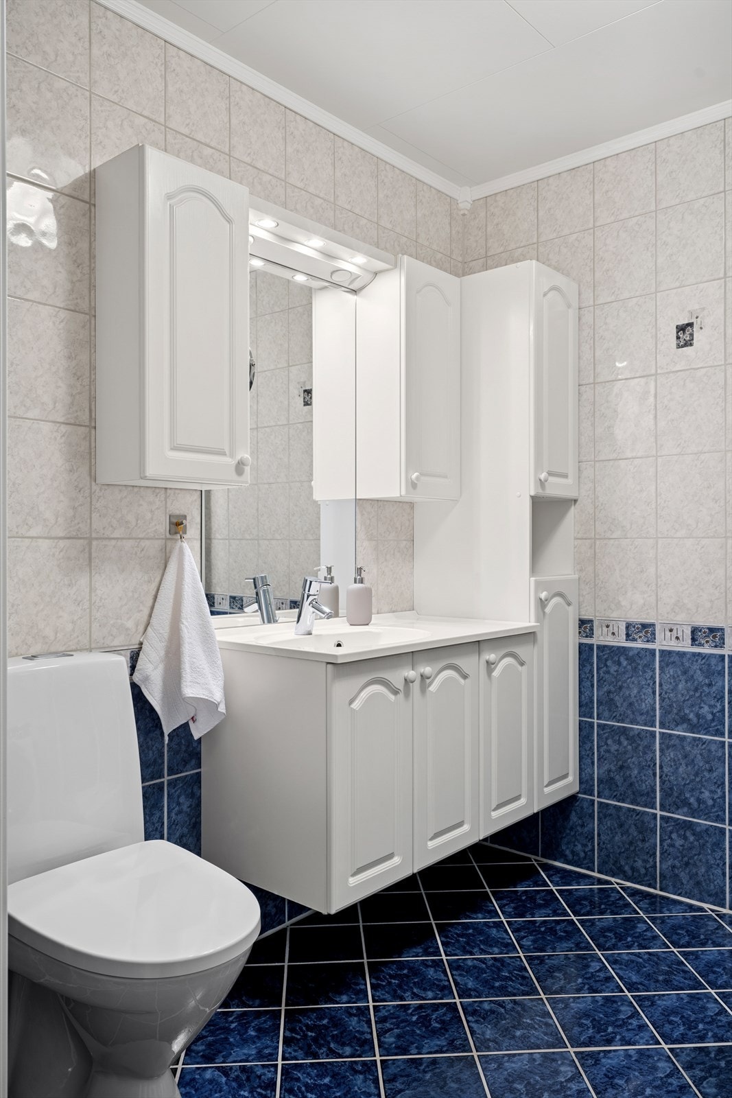 Badet er utstyrt med en romslig servantinnredning, toalett, dusjkabinett og opplegg for vaskemaskin. Galleribilde