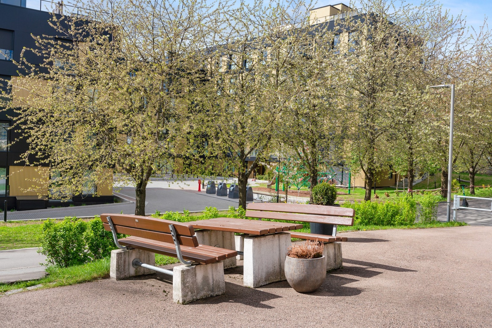 Tomten er pent opparbeidet med asfalterte internveier, sittegruppe og enkel beplantning Galleribilde