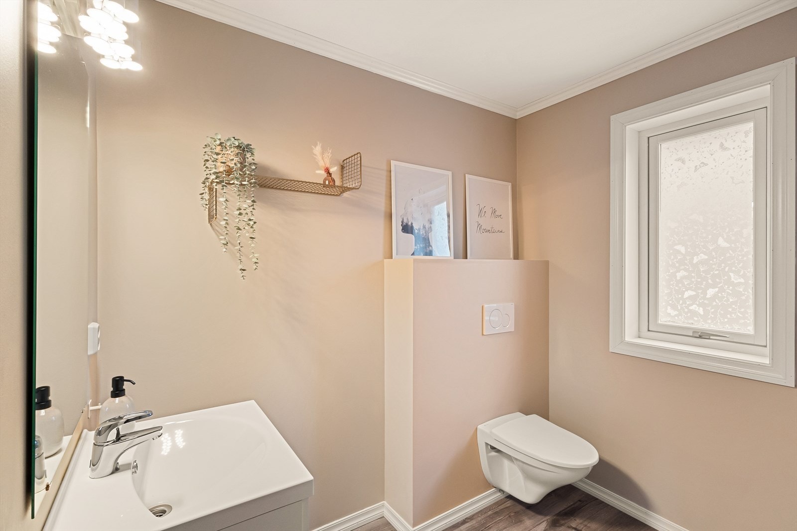 Toalettrommet har laminat på gulv, malt platekledning på vegger og i himling. Her er det ellers innredet med det man trenger som servant med møblement/speil, belysning og vegghengt toalett. Galleribilde