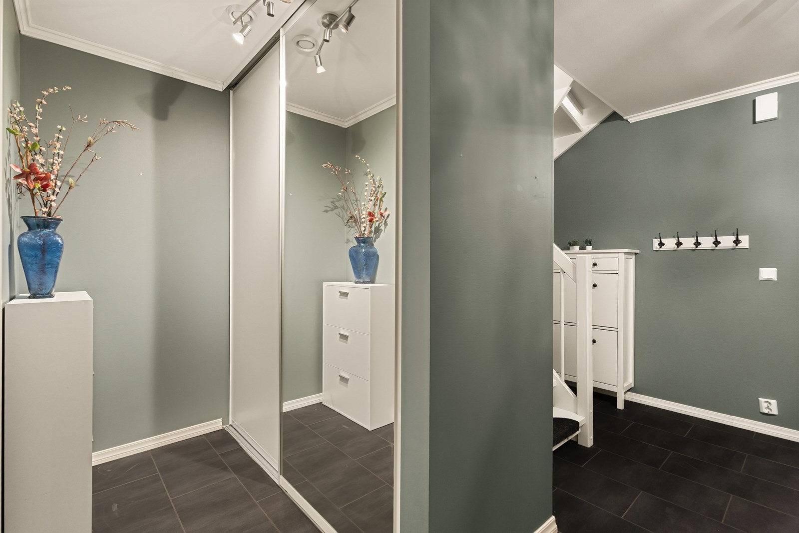 Plass til yttertøy på oppheng, skoskap under trappen og skyvedørsgardeobe med speilfronter. Galleribilde