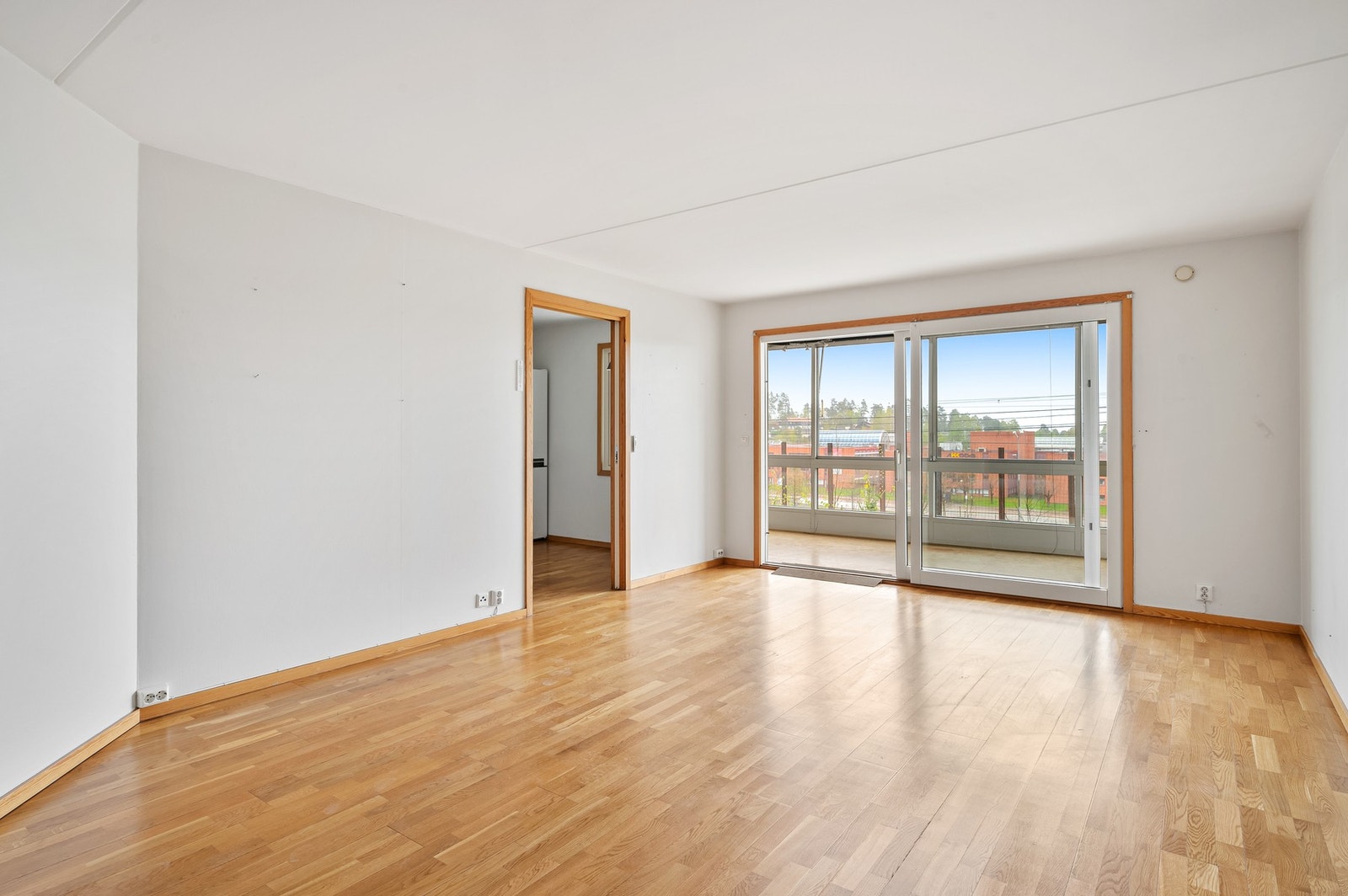 Stor skyvedør mellom balkong og stue sørger for rikelig med naturlig lys i stuen. Galleribilde