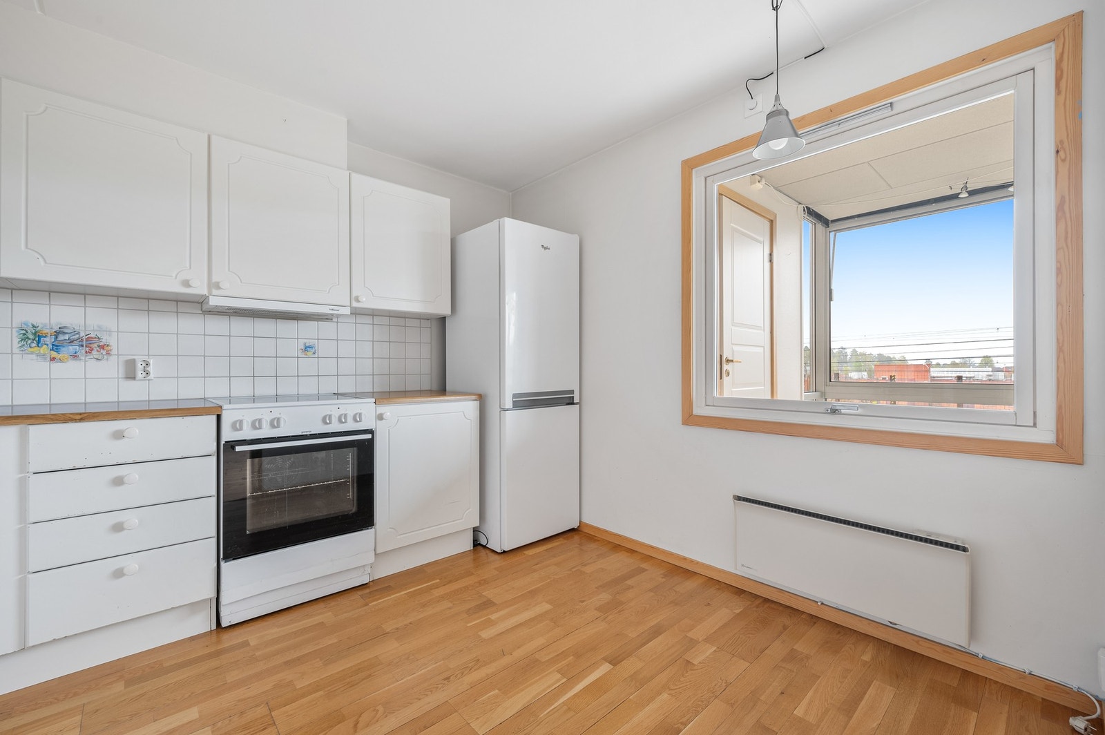 Kjøkken med hvite profilerte fronter fra byggeår. Benkeplate av laminat. Galleribilde