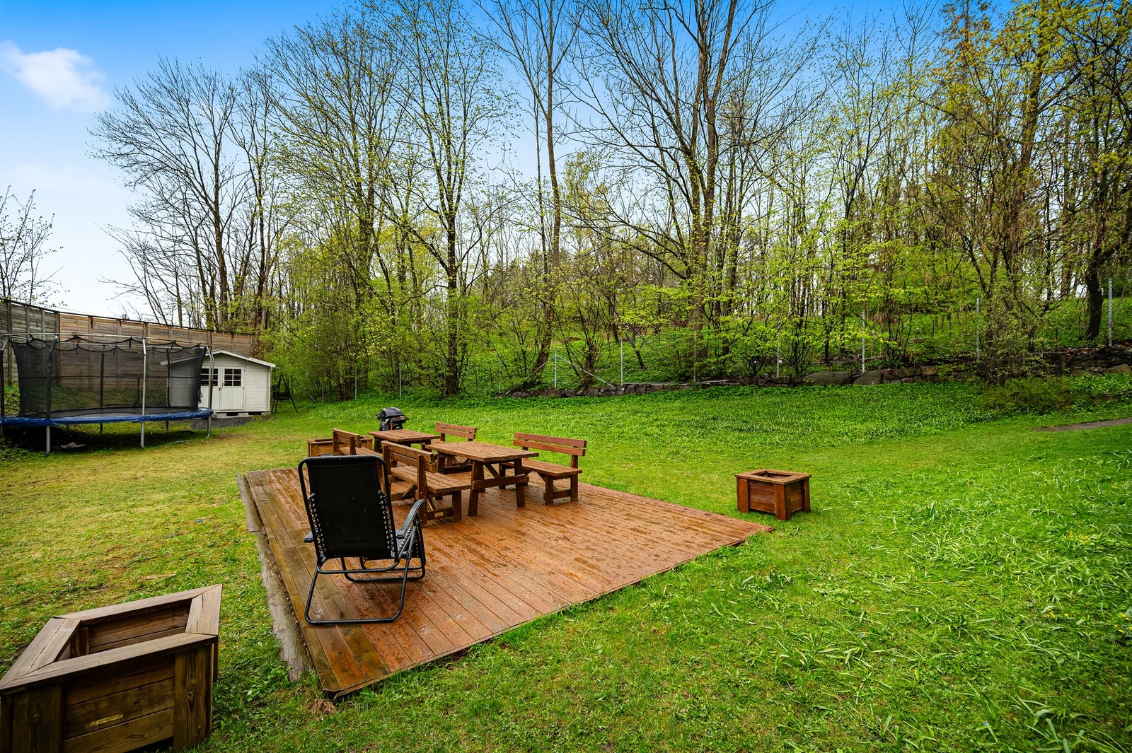 Felles uteplass med benker, bord og grill som beboerne kan benytte seg av. Galleribilde