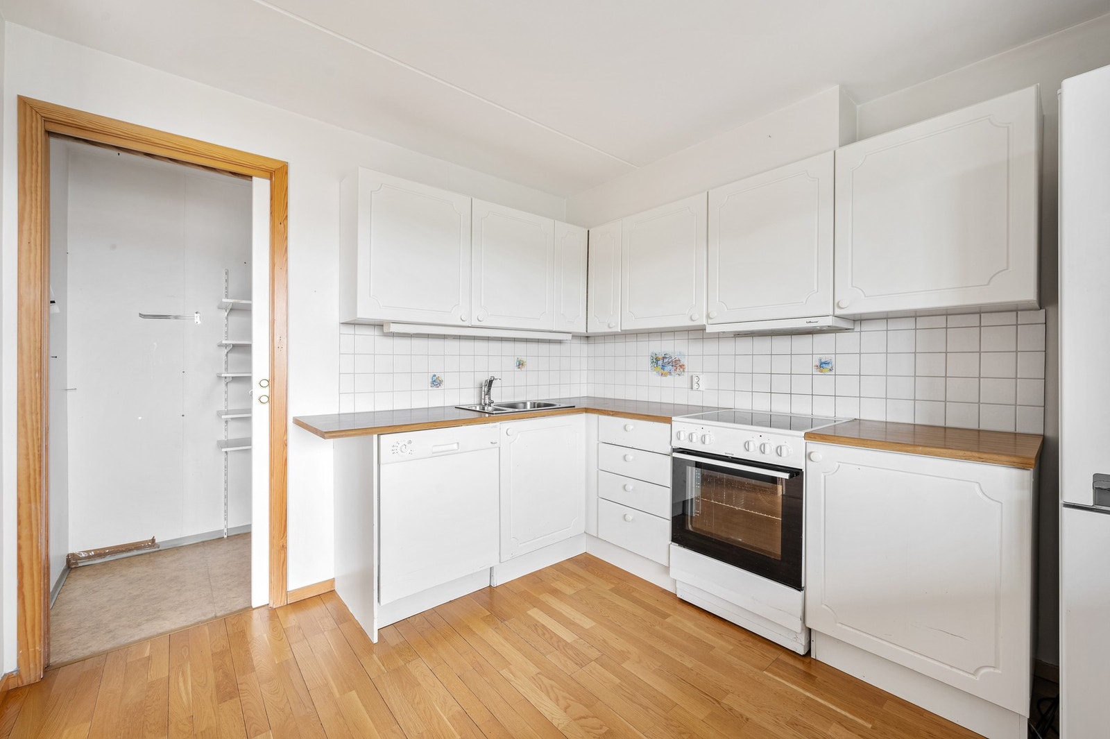 Kjøkkenet er utstyrt med hvitevarer som komfyr, oppvaskmaskin og kjøleskap med frysedel. Ventilator plassert i overskap. Galleribilde