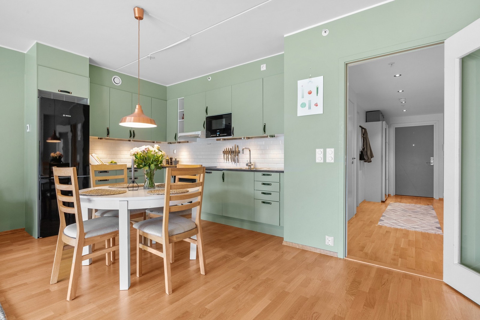 Innredningen har glatte fronter som ble lakkert i 2022, og i en grå laminatbenkeplate er det planlimt kum i stål. Kjøkkenveggene ble malt opp i 2023. Galleribilde