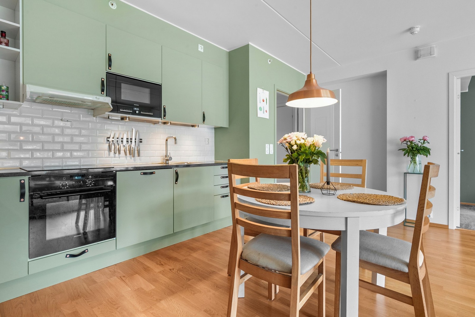 Veggene over benken er kledd med hvite metrofliser, og under overskapene er det montert god arbeidsbelysning. Galleribilde