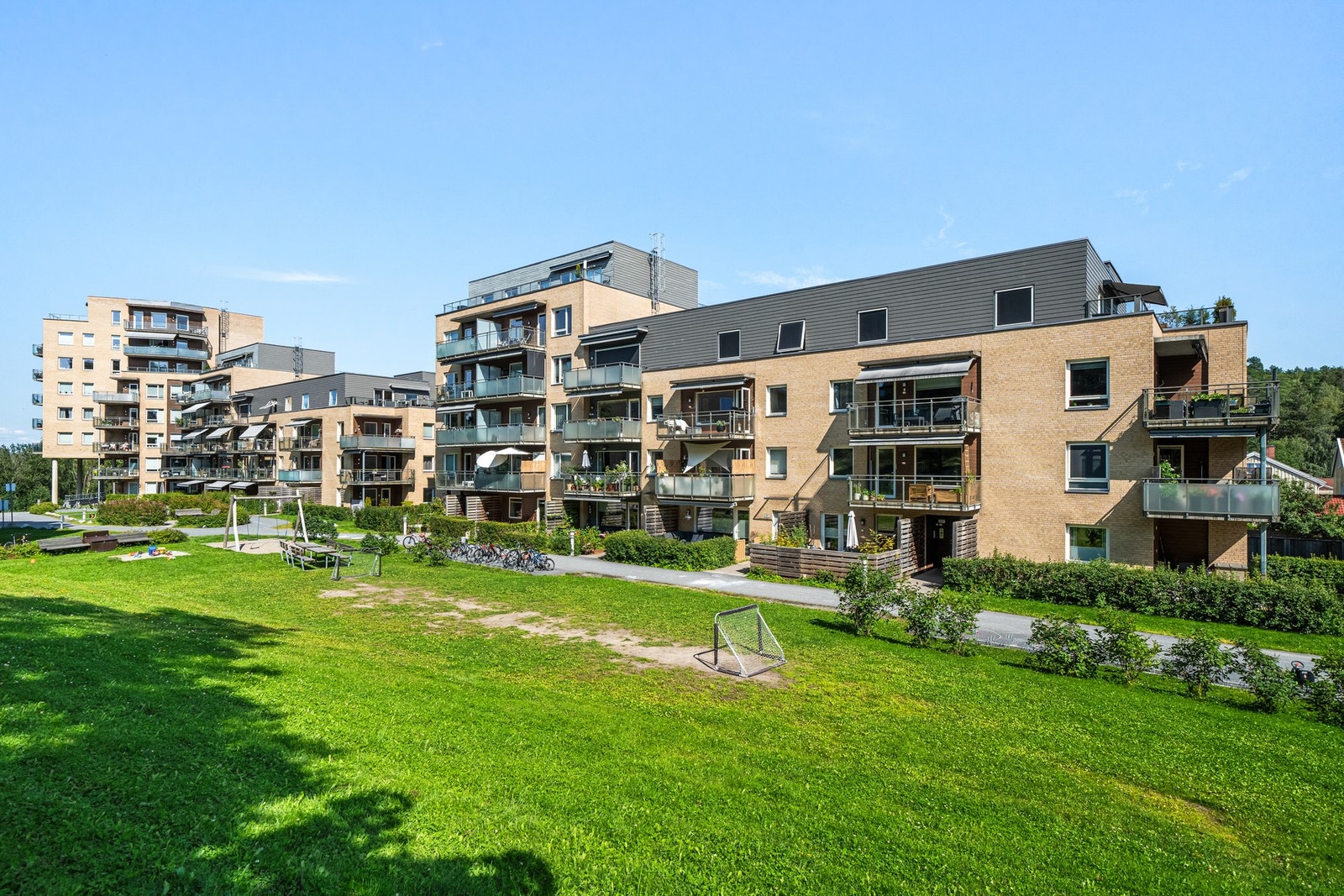Bygningen omkranses av velholdte fellesarealer, bestående av asfalterte internveier og store gressplener beplantet med prydbusker. Galleribilde