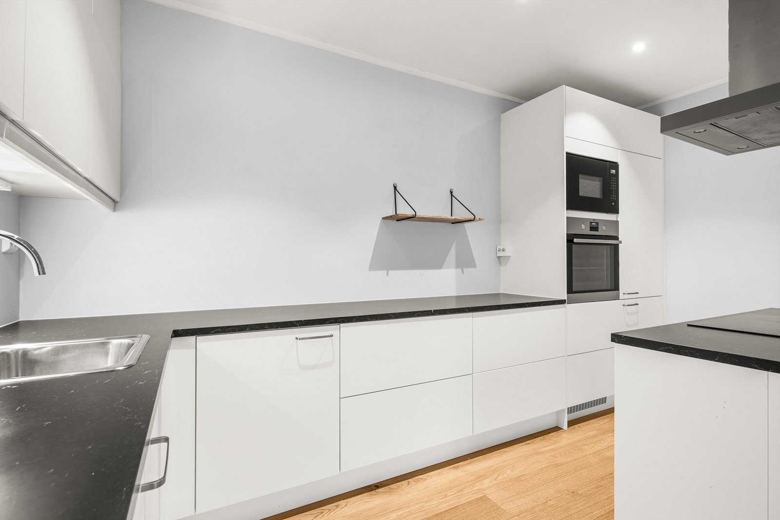 Nedfelt oppvaskkum og integrerte hvitevarer som oppvaskmaskin, stekeovn, mikrobølgeovn, koketopp og kombiskap sørger for en sømløs og funksjonell kjøkkenopplevelse. Galleribilde