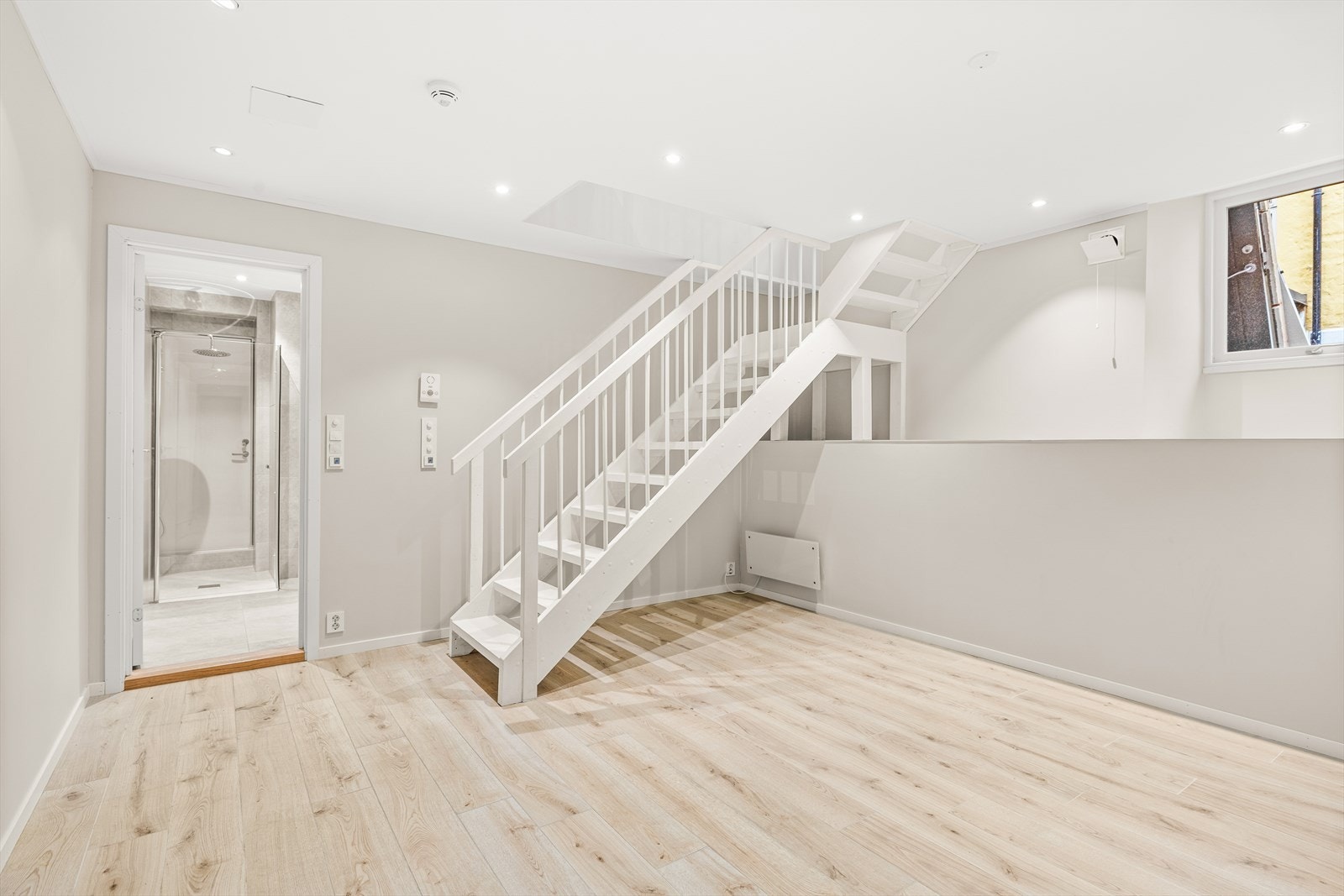 Stor og lys kjellerstue malt i en behagelig lys beigetone, med god plass til sofagruppe, salongbord og TV-møblement. Galleribilde