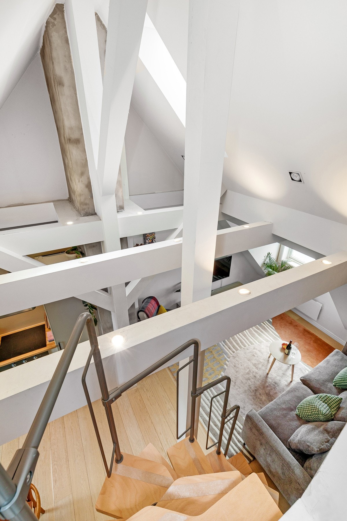 Sjenerøs takhøyde (mønehøyde på 4,58 m), malte bjelker, downlights og uplights gir leiligheten et unikt preg. Galleribilde