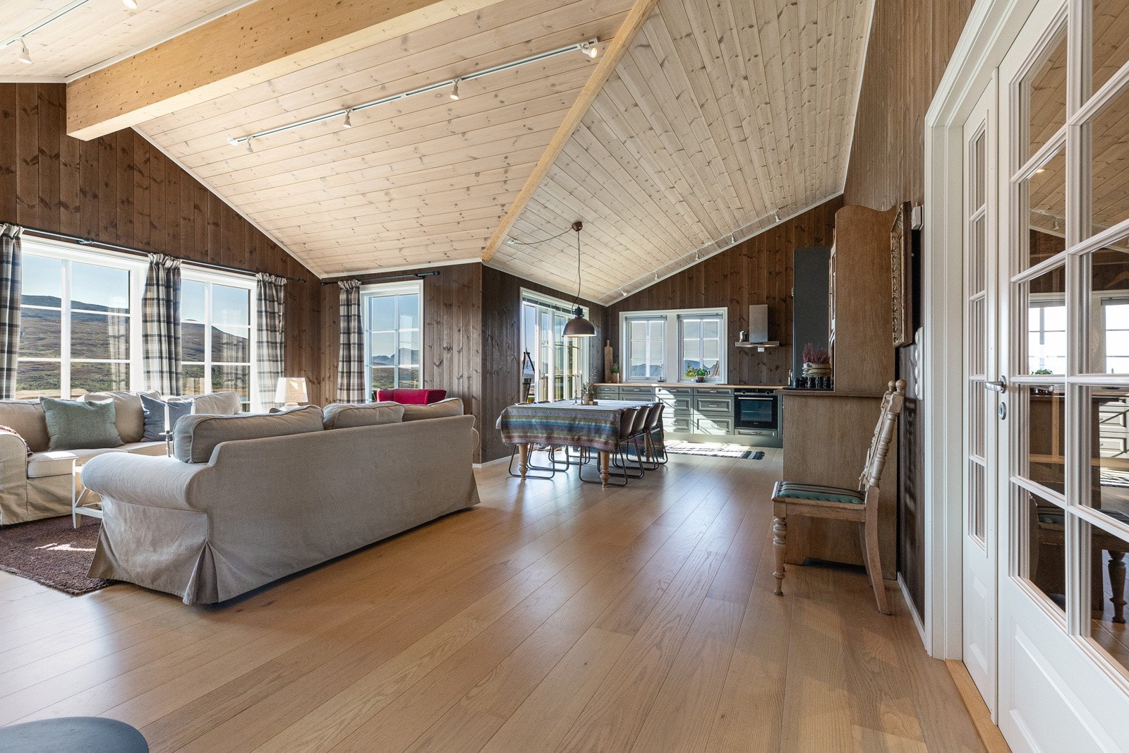 Stuen er åpen og inkluderende og har god takhøyde med forskjellige vinkler i konstruksjonen. Galleribilde