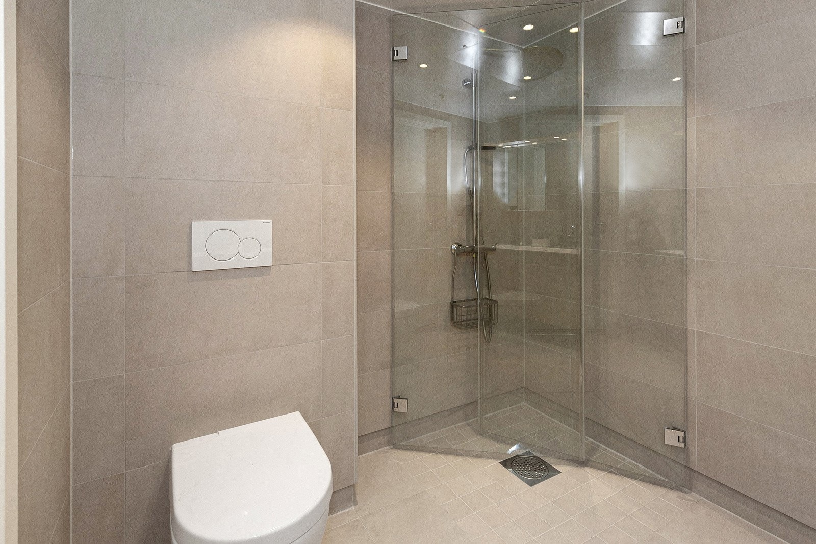 Badet har dusjhjørne, dobbel servant i innredning, vegghengt toalett (Villeroy & Boch) og opplegg for vaskemaskin Galleribilde