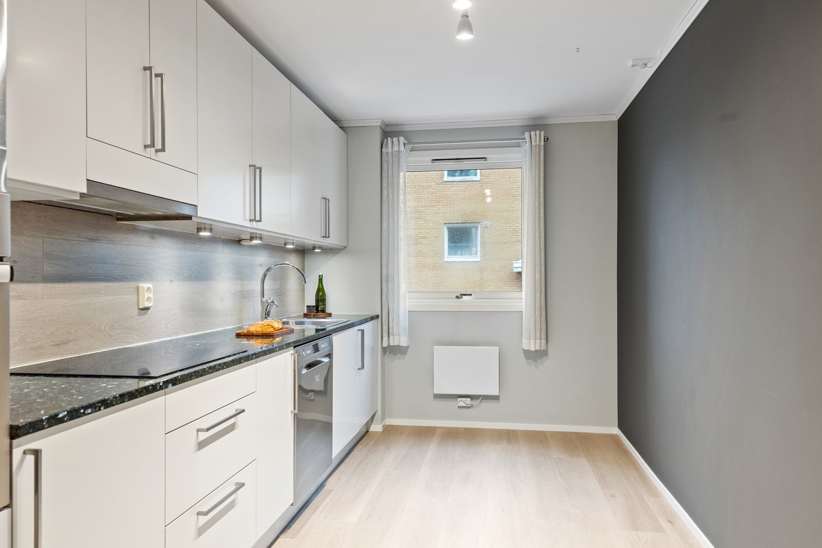 Lekkert kjøkken fra 2019 med slette fronter og benkeplate av stein. Galleribilde