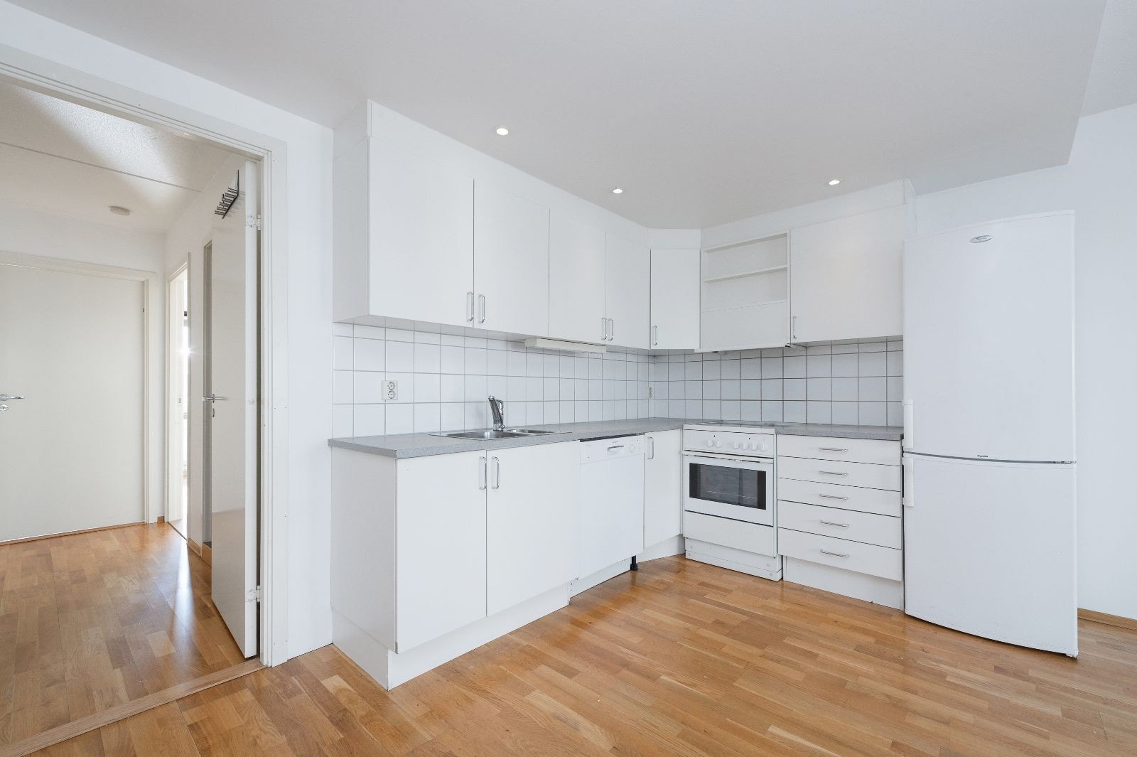 Lyst kjøkken med alt av hvitevarer. Galleribilde