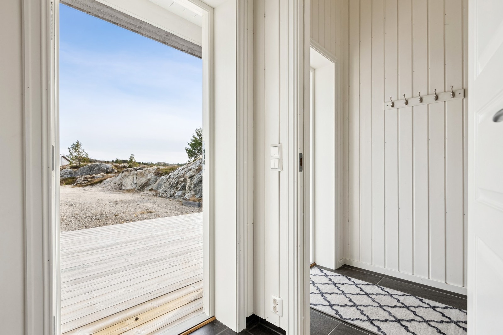 Entréen har flislagt gulv med gulvvarme. Her kan man henge fra seg yttertøyet. Galleribilde